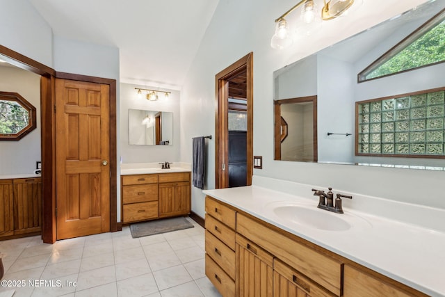 bathroom featuring tile patterned floors, vanity, and lofted ceiling