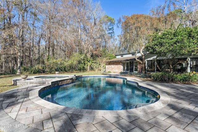 view of pool with a patio area and an in ground hot tub