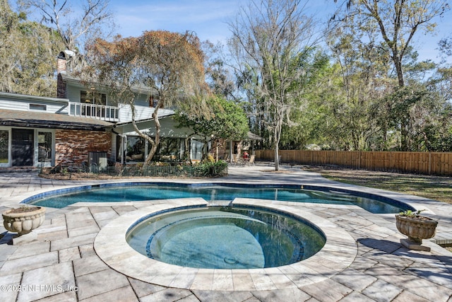 view of pool with an in ground hot tub and a patio