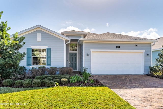 view of front of property featuring a front yard and a garage