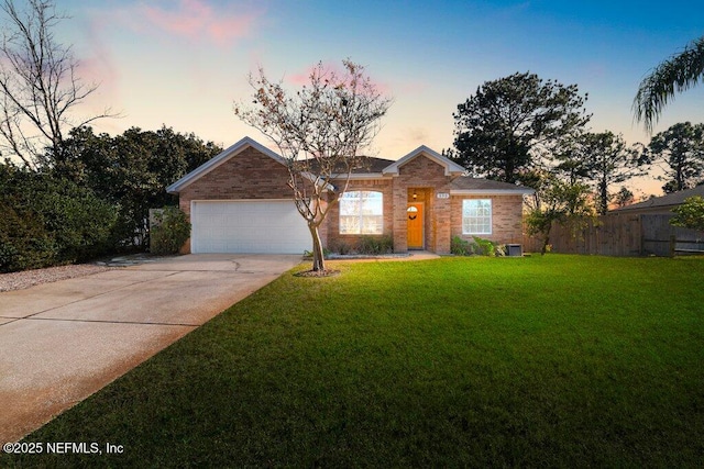 single story home with a garage and a lawn