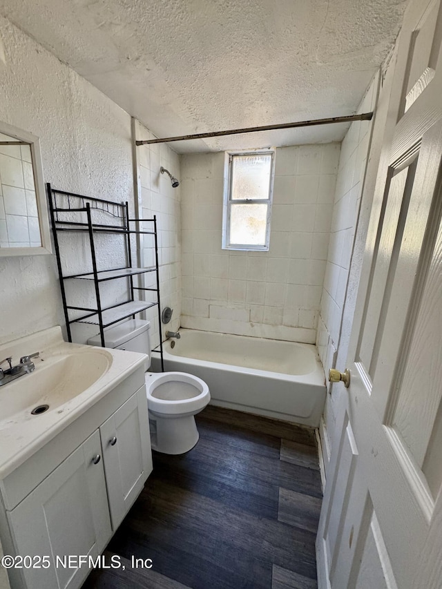 full bathroom featuring vanity, a textured ceiling, hardwood / wood-style flooring, and tiled shower / bath