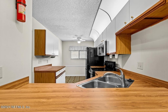 kitchen featuring black appliances, white cabinets, sink, ceiling fan, and a textured ceiling