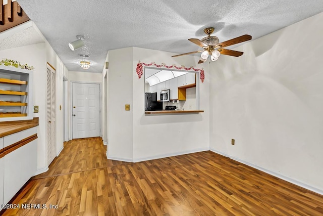 interior space featuring a textured ceiling, hardwood / wood-style flooring, and ceiling fan