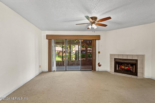 unfurnished living room featuring carpet, ceiling fan, a textured ceiling, and a tile fireplace