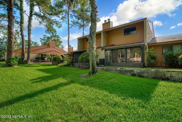 back of house with a lawn and central AC