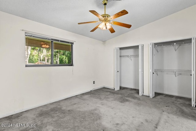 unfurnished bedroom with carpet flooring, multiple closets, ceiling fan, a textured ceiling, and lofted ceiling