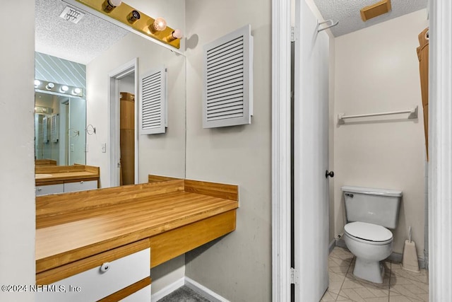 bathroom featuring a textured ceiling and toilet