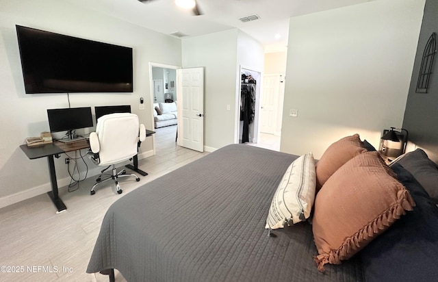 bedroom with light hardwood / wood-style floors, a spacious closet, and a closet