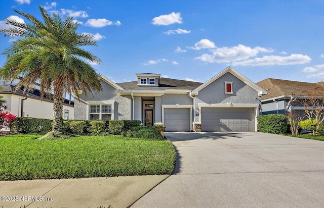 view of front of property featuring a front yard and a garage