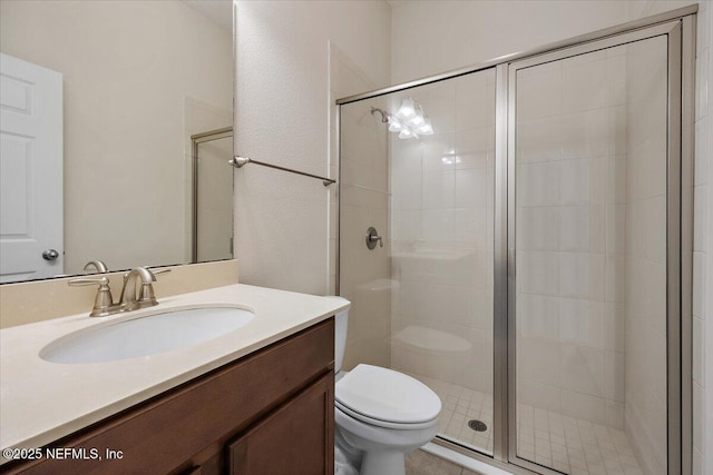 bathroom with vanity, toilet, and a shower with door