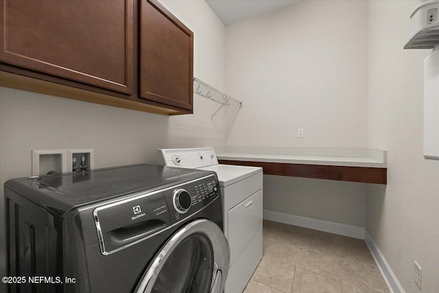 laundry room featuring cabinets, independent washer and dryer, and light tile patterned floors