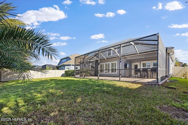 back of property with a bar, a yard, glass enclosure, and a patio area