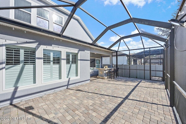 view of patio / terrace with exterior bar and a lanai