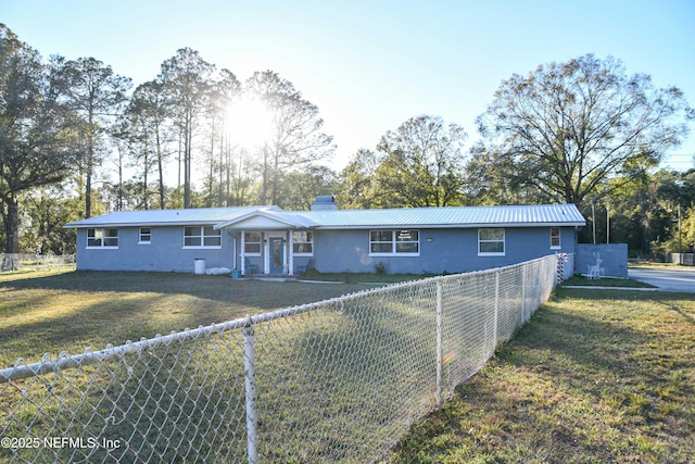 view of front of home with metal roof, fence private yard, a chimney, and stucco siding