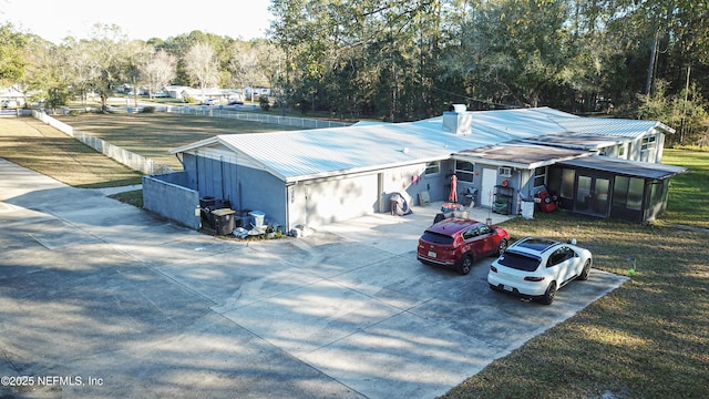 exterior space with a carport, a sunroom, and metal roof