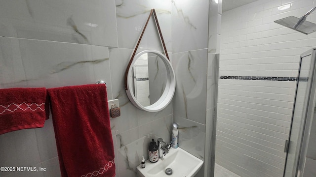 bathroom featuring tasteful backsplash, tile walls, walk in shower, and sink