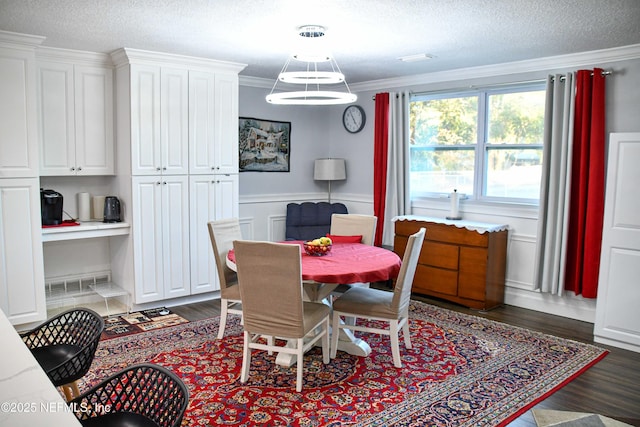 dining room with crown molding, dark wood-type flooring, and a textured ceiling