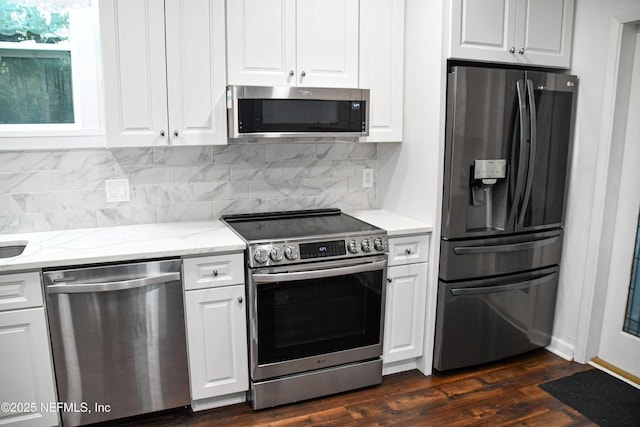 kitchen featuring light stone countertops, appliances with stainless steel finishes, backsplash, dark wood-type flooring, and white cabinets