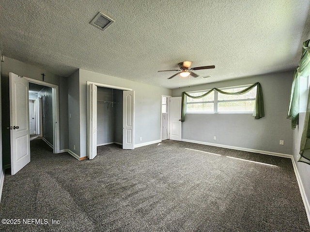 unfurnished bedroom featuring baseboards, visible vents, ceiling fan, a closet, and dark colored carpet