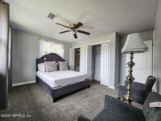 bedroom with baseboards, visible vents, two closets, and carpet