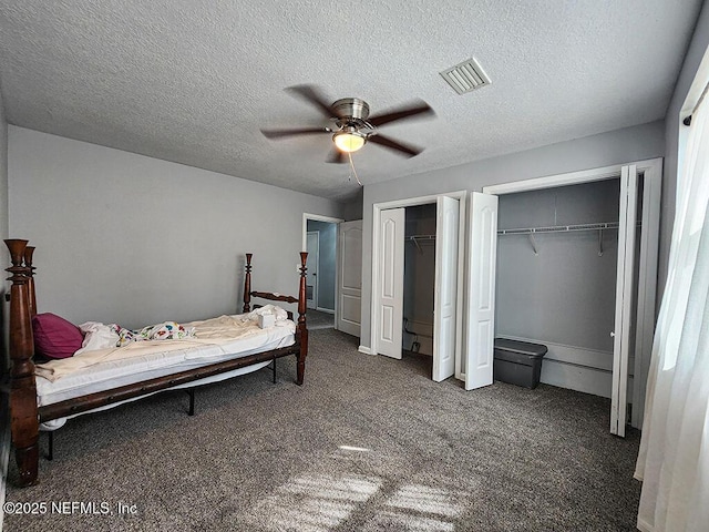 carpeted bedroom with ceiling fan, visible vents, multiple closets, and a textured ceiling