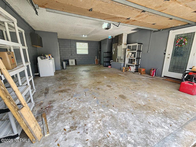 garage featuring washer / dryer, a garage door opener, and concrete block wall