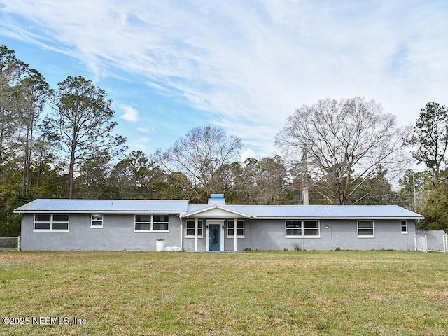 single story home with metal roof, a front lawn, and fence