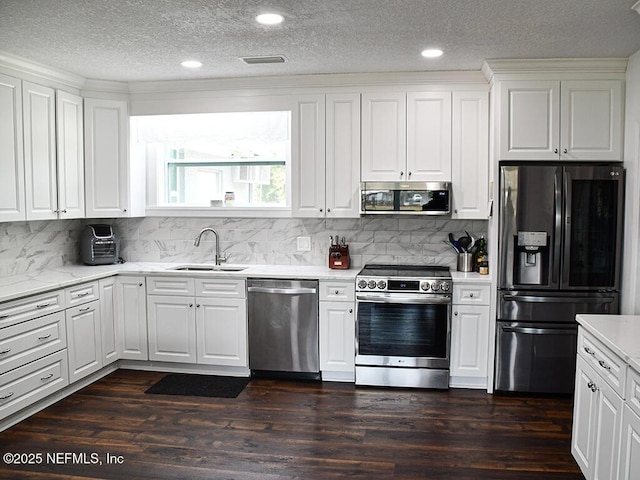 kitchen with a sink, dark wood-type flooring, visible vents, and stainless steel appliances