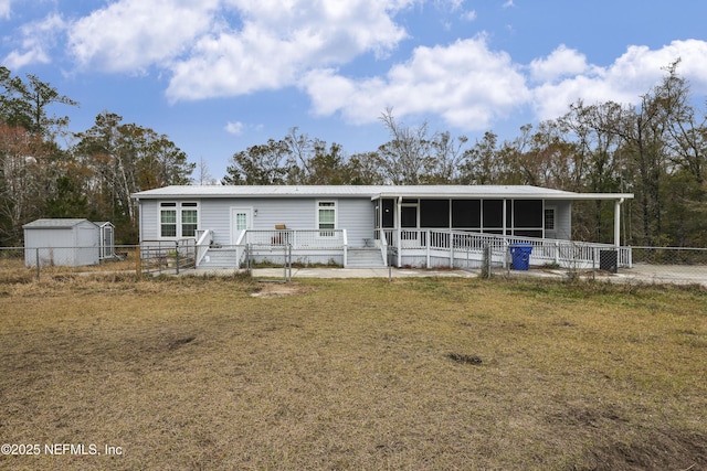 view of front of house with a storage unit and a front yard