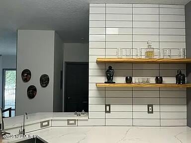 interior space with light stone countertops, a textured ceiling, and sink