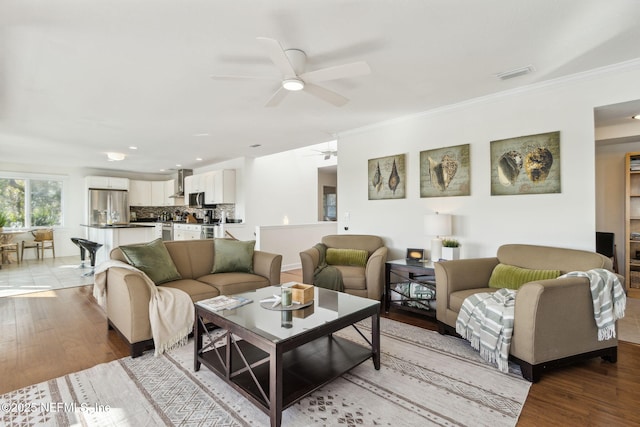 living room with ceiling fan, light hardwood / wood-style flooring, and crown molding