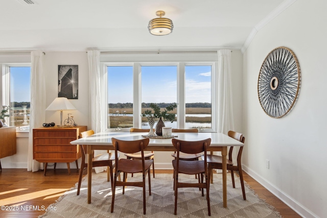 dining space featuring hardwood / wood-style flooring and ornamental molding