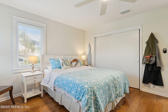 bedroom with dark hardwood / wood-style flooring, a closet, and ceiling fan