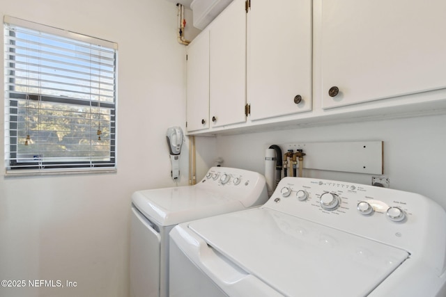 laundry area with washer and clothes dryer and cabinets