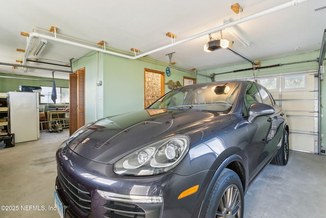 garage with white refrigerator and a garage door opener