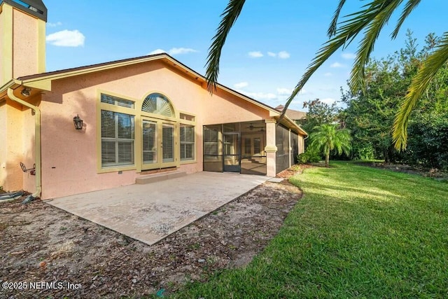 rear view of property with a sunroom, a patio area, and a yard