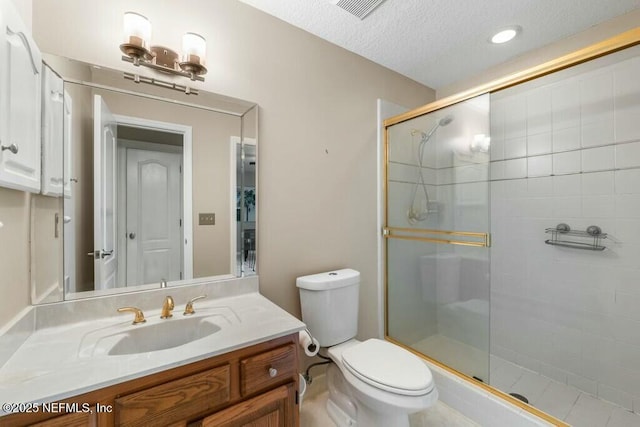 bathroom with a textured ceiling, vanity, an enclosed shower, and toilet