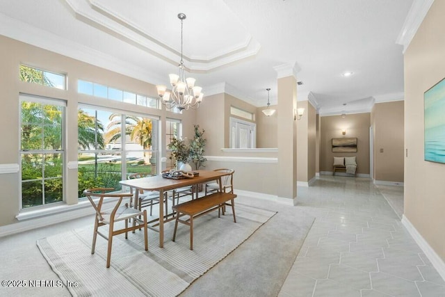 dining area featuring a tray ceiling, crown molding, and a notable chandelier