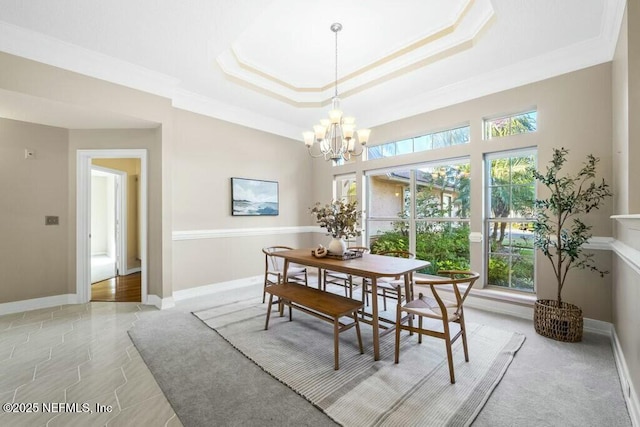 dining area featuring a notable chandelier, a raised ceiling, light tile patterned floors, and crown molding