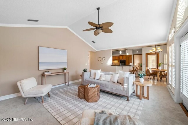 carpeted living room featuring ceiling fan with notable chandelier, crown molding, and vaulted ceiling