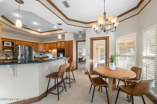 kitchen with stainless steel fridge with ice dispenser, black oven, a raised ceiling, and pendant lighting