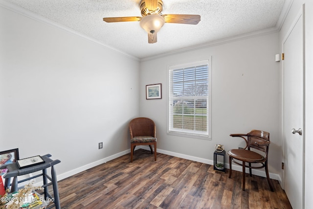 living area featuring dark hardwood / wood-style floors, ceiling fan, ornamental molding, and a textured ceiling