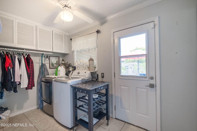 laundry room featuring cabinets, crown molding, ceiling fan, washing machine and dryer, and light tile patterned floors