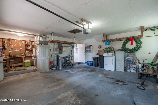 garage featuring a workshop area, washer and clothes dryer, and a garage door opener