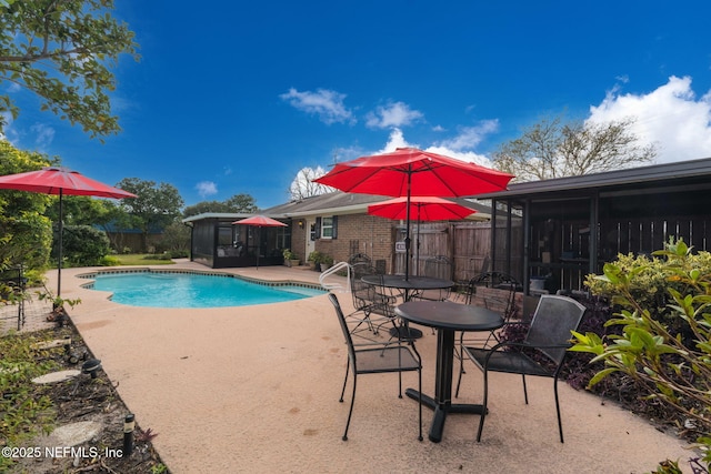 view of swimming pool featuring a patio area and a sunroom