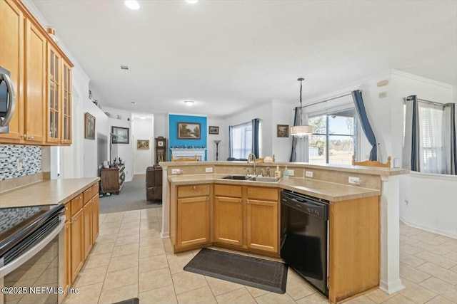 kitchen featuring decorative light fixtures, sink, black dishwasher, and a kitchen island with sink