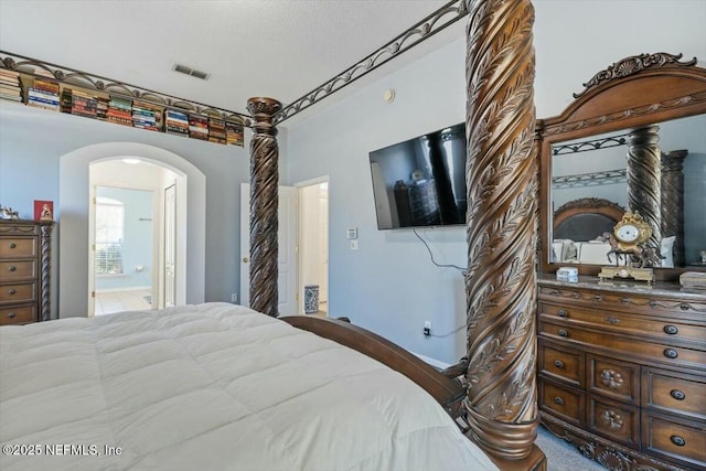 bedroom featuring connected bathroom and a textured ceiling