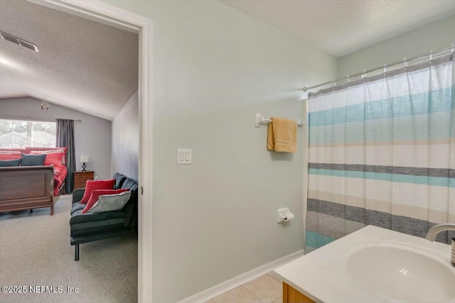 bathroom featuring a textured ceiling, vanity, vaulted ceiling, and a shower with shower curtain