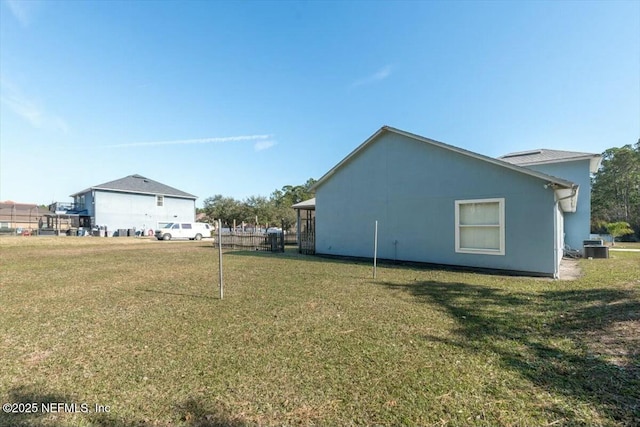 exterior space featuring central air condition unit and a lawn